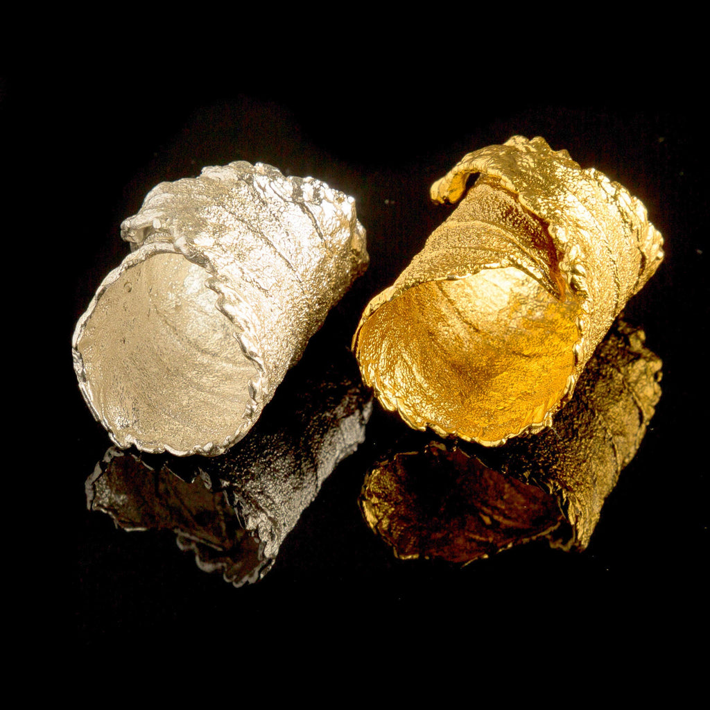 Two gold-colored objects, one silver-colored and one gold-colored, are placed on a black background.