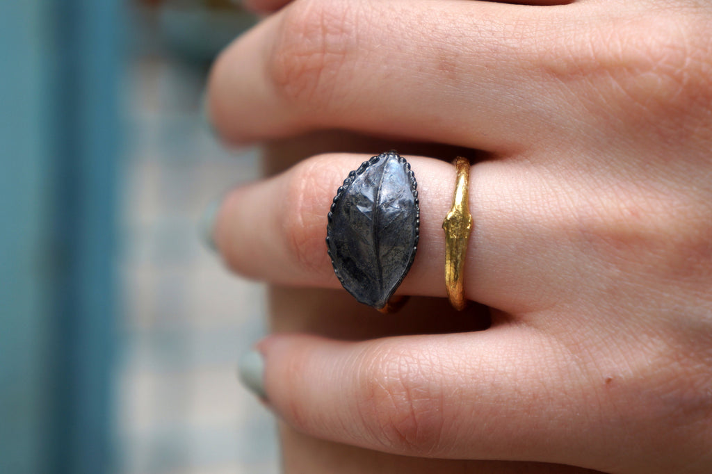 A close-up of a person's hand wearing two rings on the fingers.