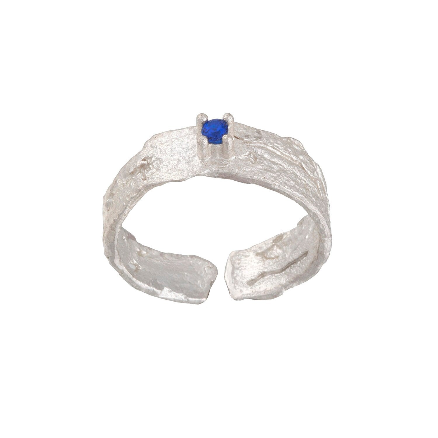 A silver ring with a blue gemstone, possibly a sapphire, set in the center.