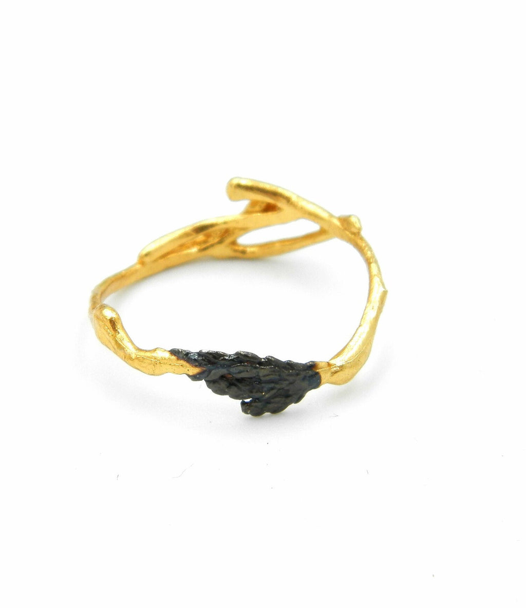 A gold ring with a leaf-shaped design on the side.