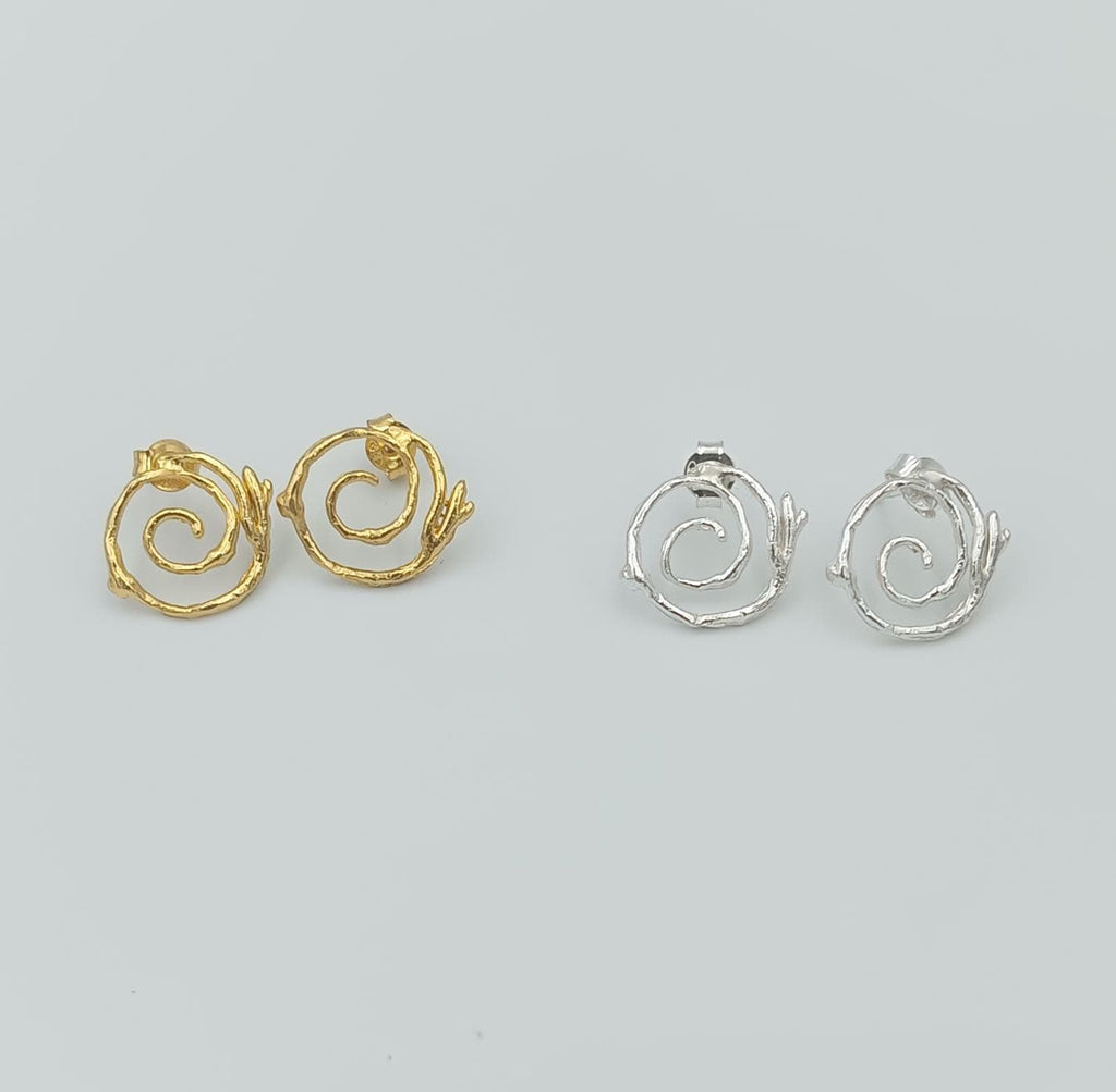 a pair of earrings, each with a unique design, arranged side by side against a light background.