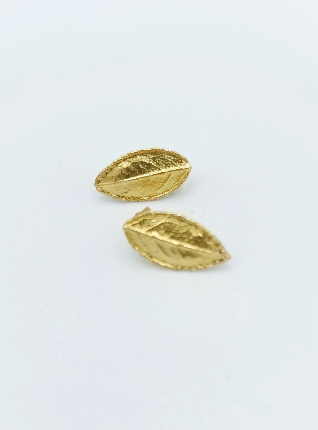 Two gold leaf earrings are shown against a white background.